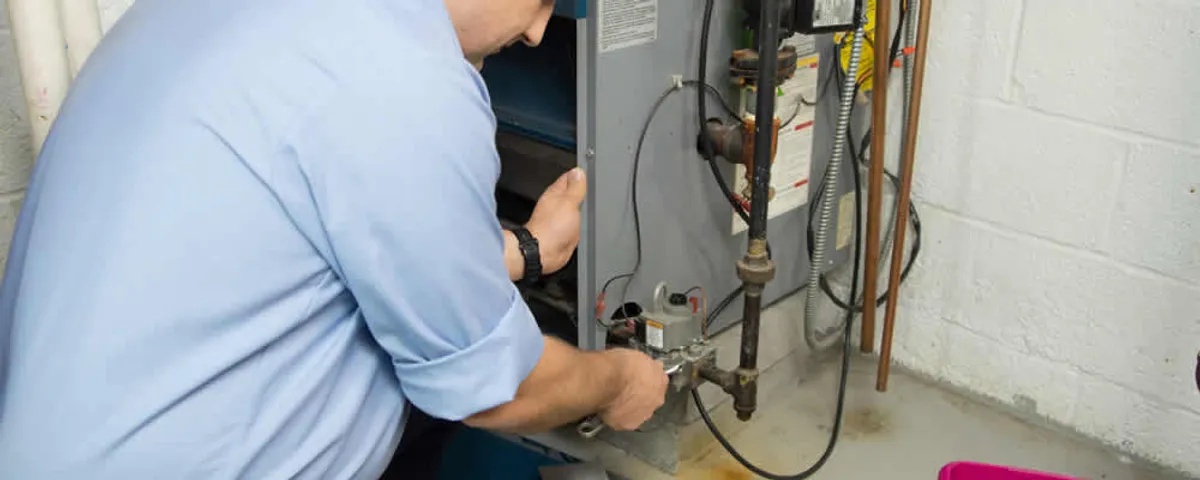 Furnace repair technician inspecting and servicing a home heating system in Seattle, WA