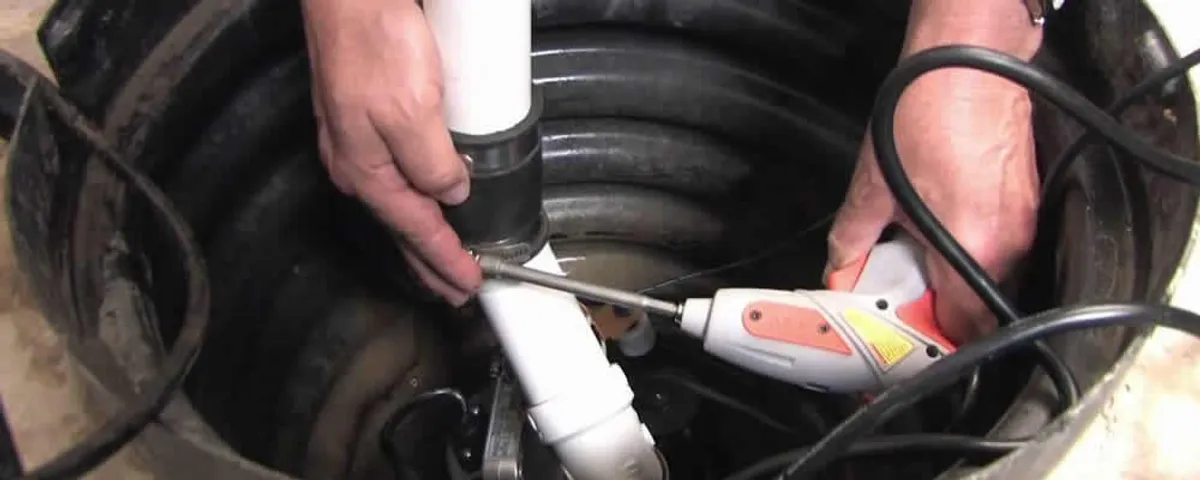 Sump pump installation technician connecting PVC discharge piping in Seattle, WA